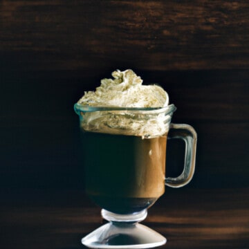 在爱尔兰咖啡杯,咖啡推动奶油在上面